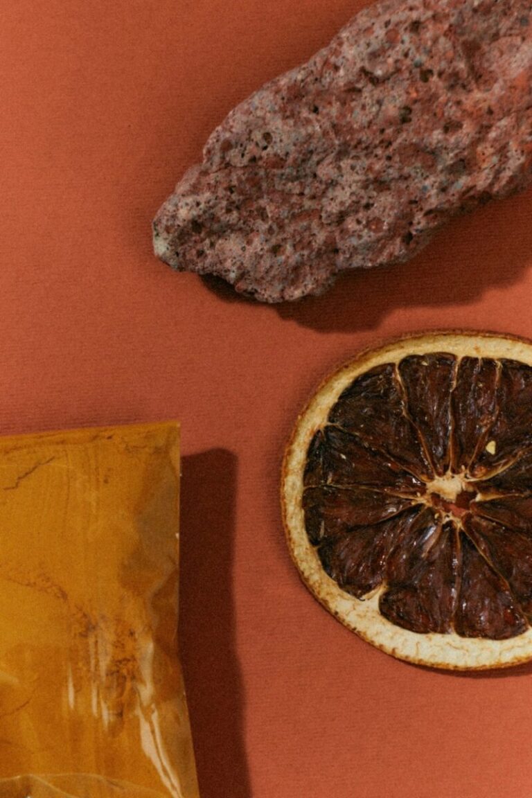 Getrocknete Orangenscheibe und natürliche Materialien in warmen Erdtönen